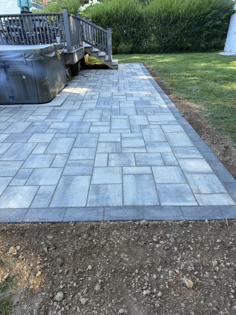 Paver patio installation around deck and hot tub in Avon Connecticut