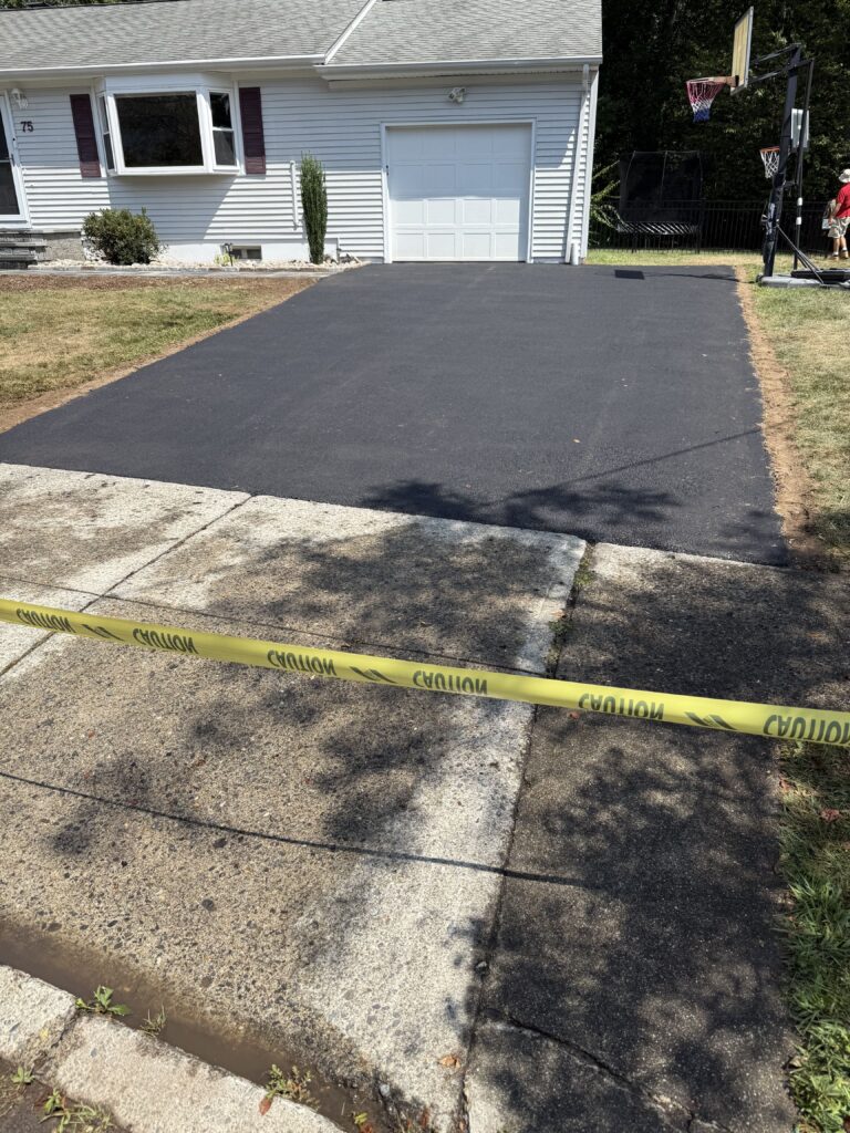 Freshly paved residential asphalt driveway with caution tape in Farmington Connecticut